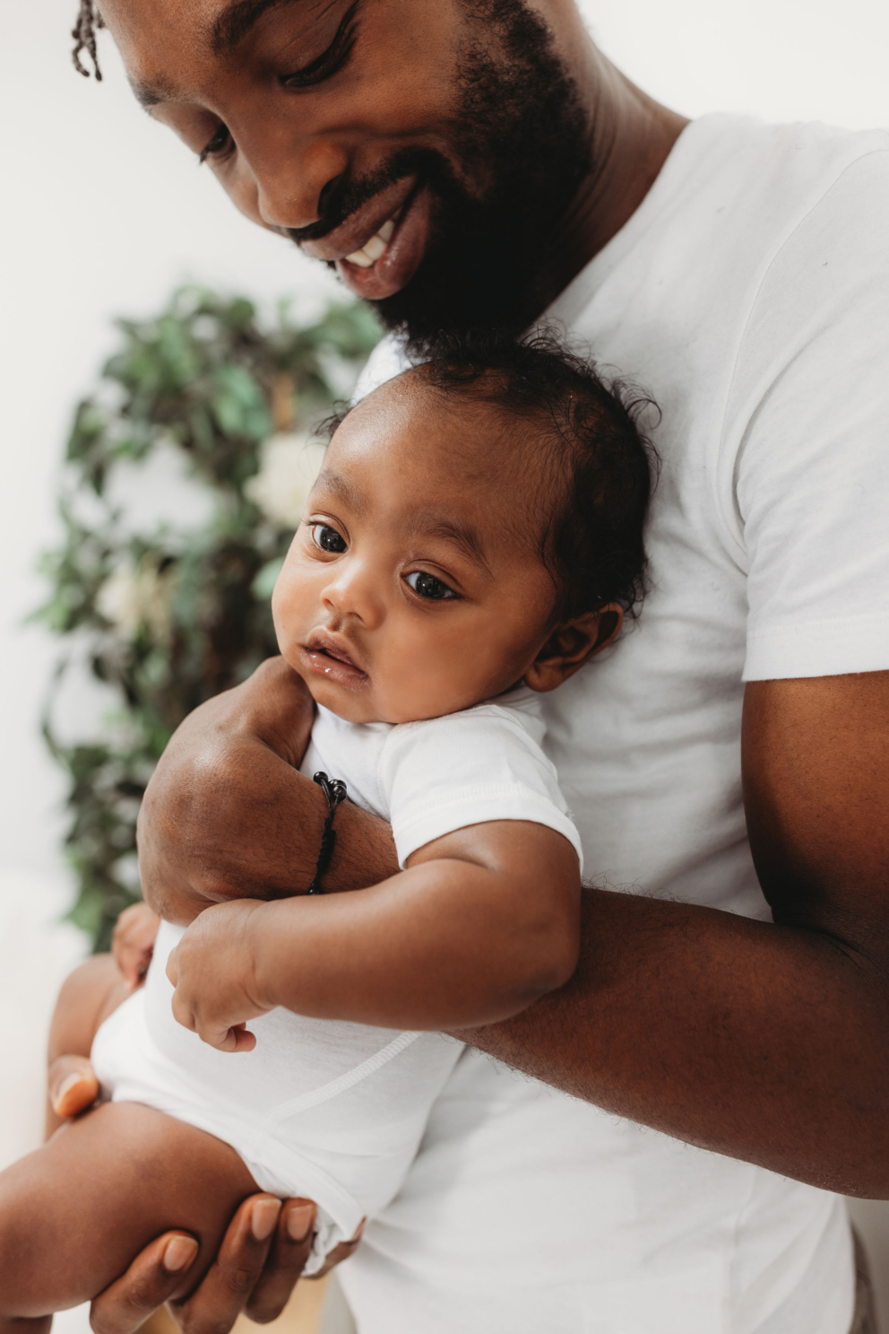 A father holding his baby in soft, skin-friendly clothing, sharing a calm and comforting moment