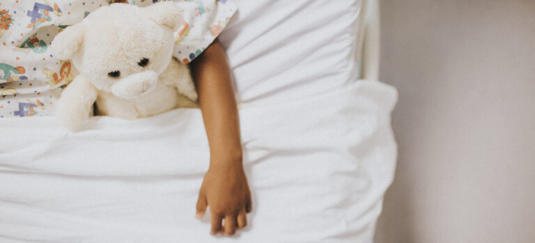 Little eczema girl sleeping in a white bed