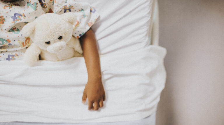Little eczema girl sleeping in a white bed